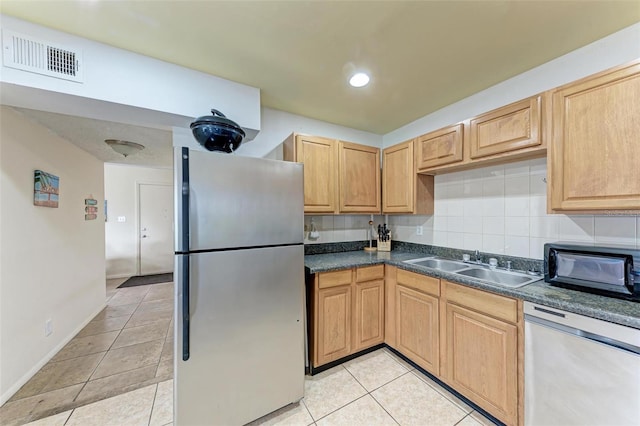 kitchen featuring appliances with stainless steel finishes, sink, decorative backsplash, light tile patterned floors, and light brown cabinets