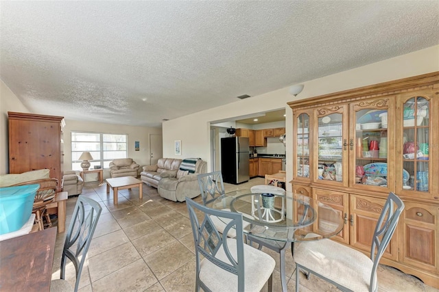 dining space with light tile patterned floors and a textured ceiling