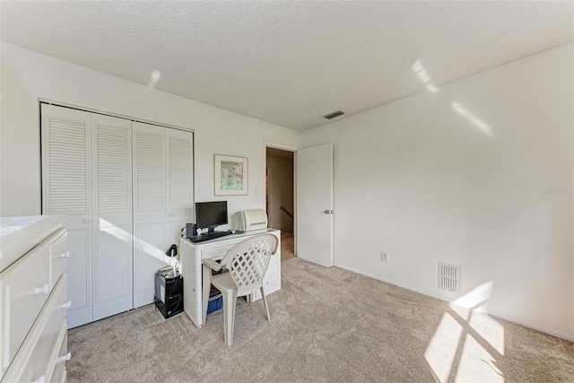 carpeted office space with a textured ceiling