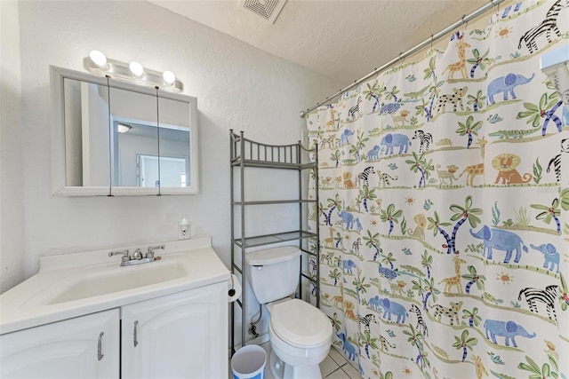 bathroom featuring vanity, walk in shower, toilet, tile patterned floors, and a textured ceiling