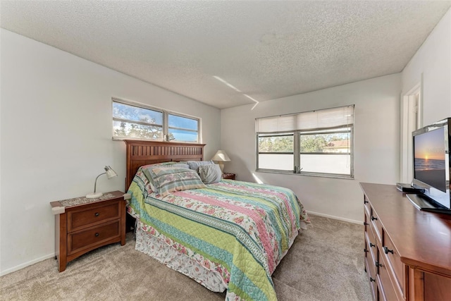 bedroom featuring light carpet and a textured ceiling