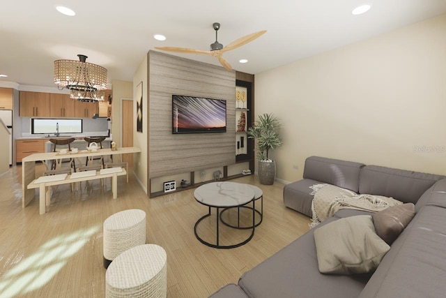 living room featuring sink, ceiling fan with notable chandelier, and light hardwood / wood-style flooring