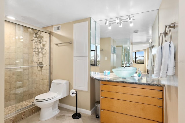 bathroom with vanity, toilet, tile patterned flooring, and a shower with door