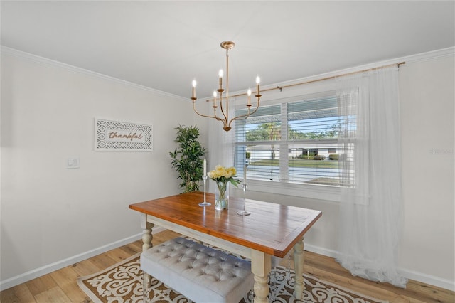 dining area featuring a chandelier, light wood-type flooring, crown molding, and baseboards