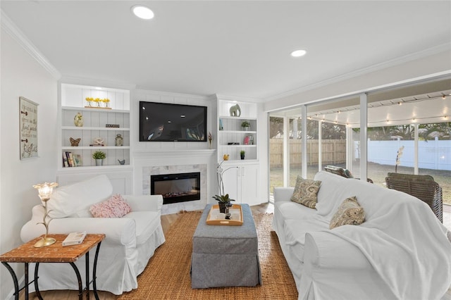 living area with built in shelves, a high end fireplace, crown molding, and recessed lighting