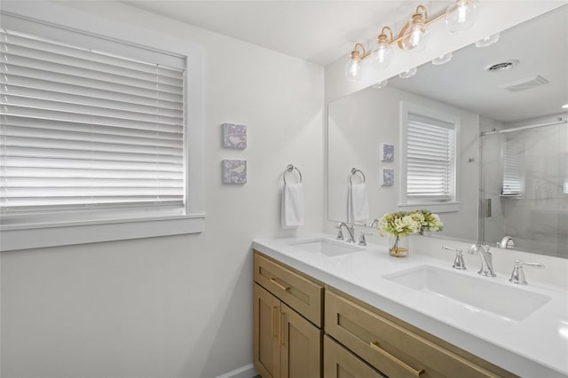 bathroom featuring a stall shower, visible vents, a sink, and double vanity