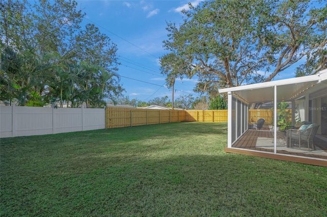 view of yard with a sunroom and a fenced backyard