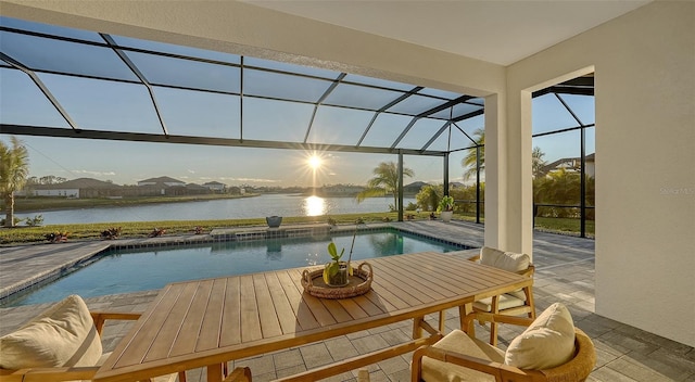 view of swimming pool with a patio, glass enclosure, and a water view