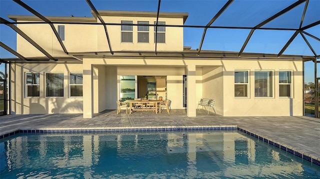 back of house featuring a patio and glass enclosure