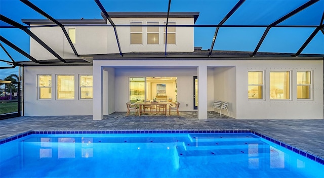 back of property with a patio area and glass enclosure