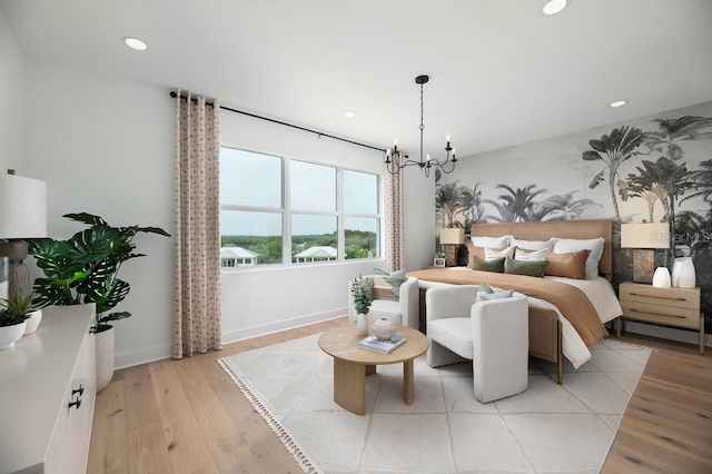 bedroom with light hardwood / wood-style flooring and a chandelier