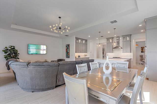 dining room featuring a raised ceiling and a notable chandelier