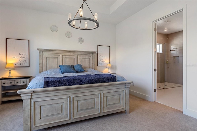 bedroom featuring an inviting chandelier, connected bathroom, and light carpet