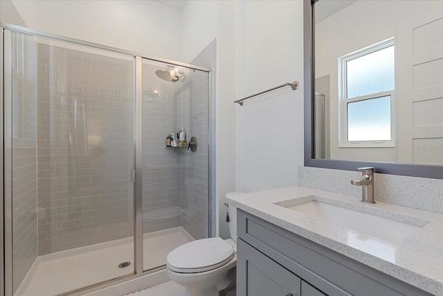 bathroom featuring vanity, an enclosed shower, and toilet