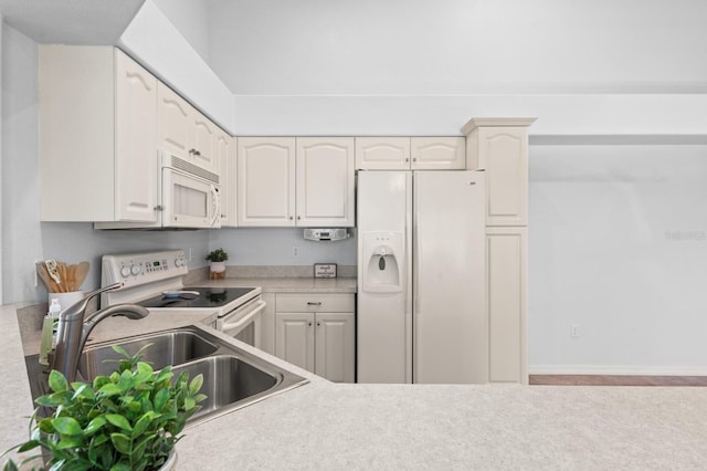 kitchen featuring white appliances, sink, and white cabinets