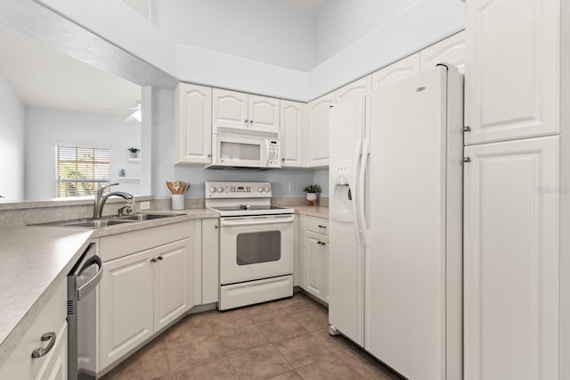 kitchen with sink, white appliances, light tile patterned floors, ceiling fan, and white cabinets