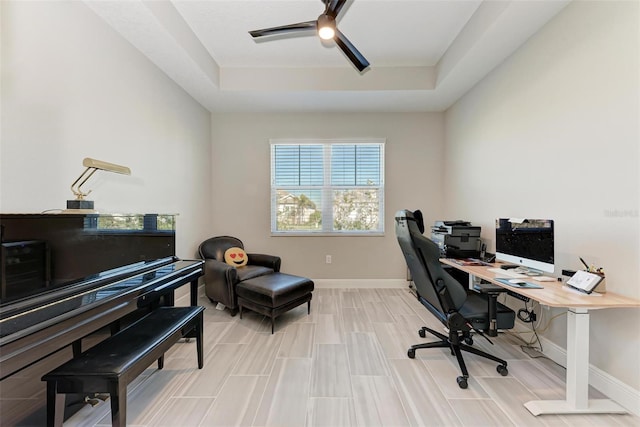 office space with ceiling fan and a tray ceiling