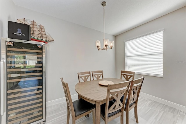 dining area featuring wine cooler and an inviting chandelier