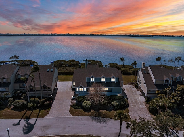 aerial view at dusk featuring a water view