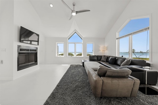 living room featuring ceiling fan, vaulted ceiling, a healthy amount of sunlight, and a water view