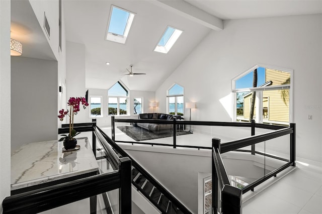 kitchen with high vaulted ceiling, light stone counters, and beam ceiling