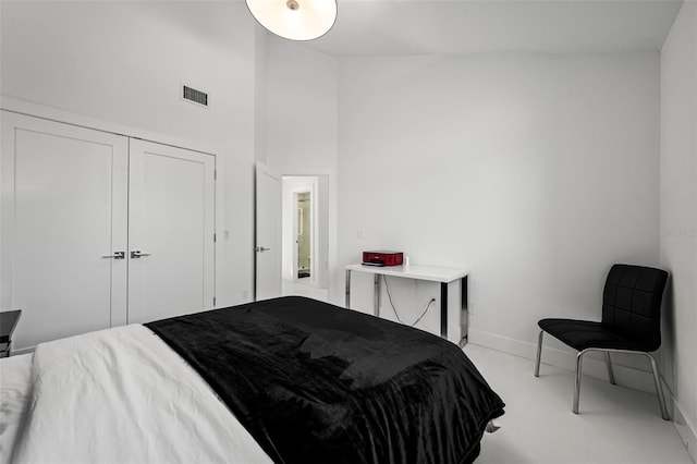 bedroom with a high ceiling and a closet