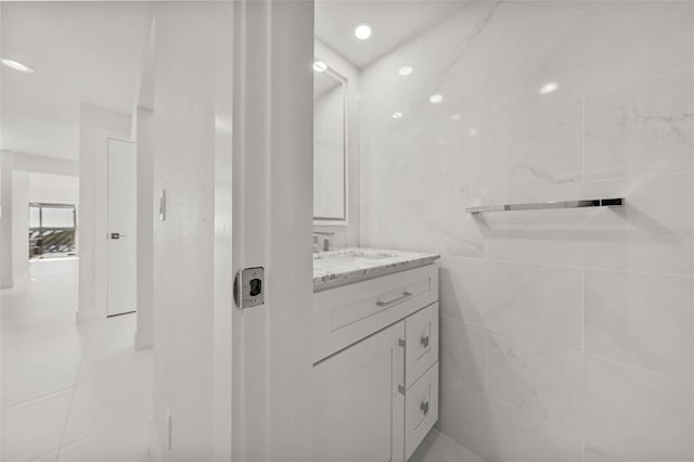 bathroom featuring vanity and tile walls