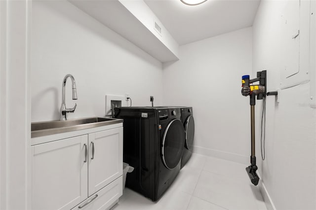 washroom featuring cabinets, washing machine and dryer, sink, and light tile patterned flooring