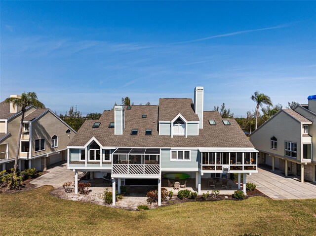 rear view of property with a patio, a sunroom, and a yard