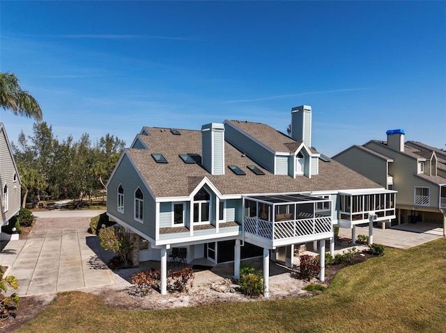 rear view of property featuring a yard and a sunroom