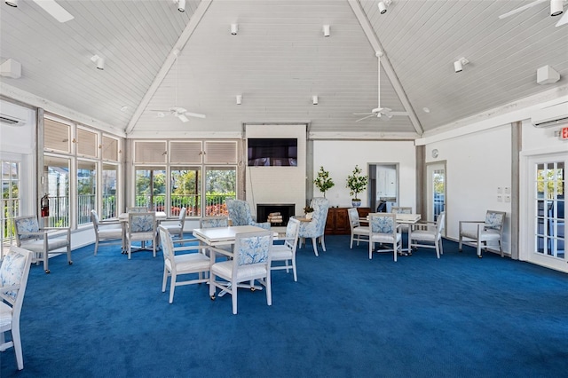 interior space featuring ceiling fan, a large fireplace, and high vaulted ceiling