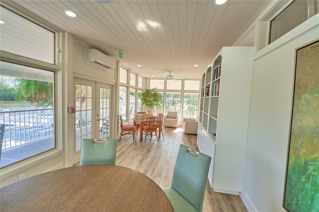 sunroom / solarium featuring ceiling fan, wood ceiling, a wall unit AC, and french doors