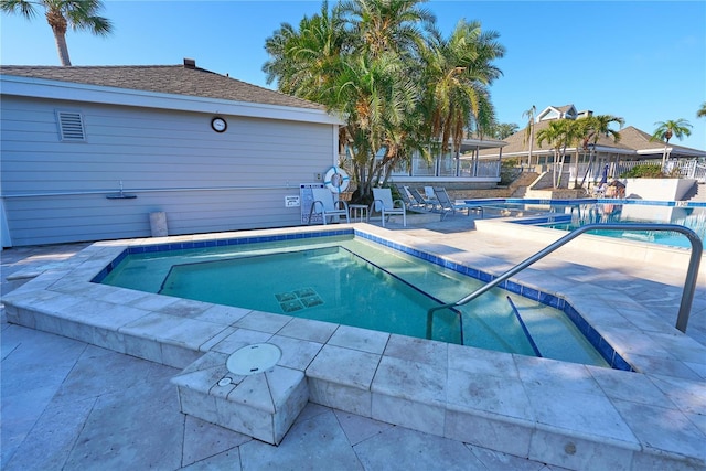 view of swimming pool featuring a patio area and a community hot tub