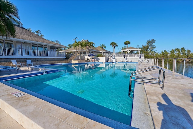 view of pool featuring a patio and a water view