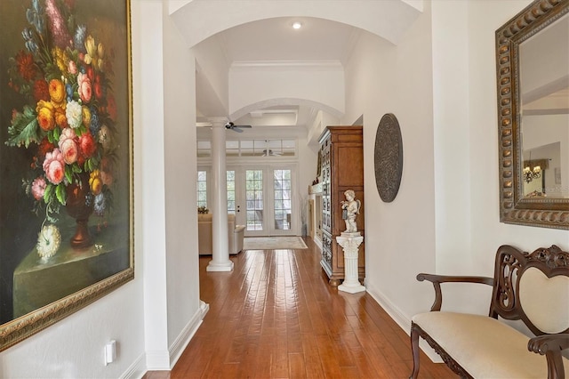 hall with crown molding, wood-type flooring, decorative columns, and french doors