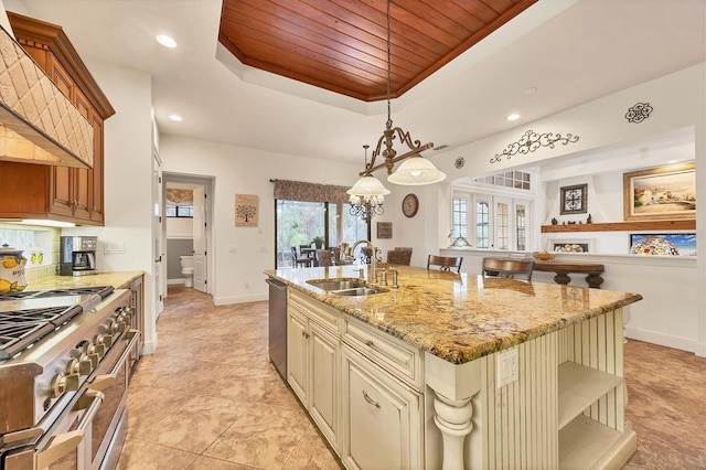 kitchen featuring sink, hanging light fixtures, an island with sink, a kitchen bar, and wooden ceiling