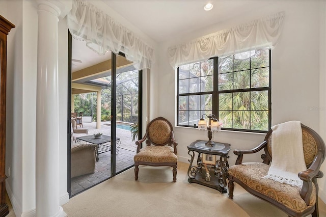 sitting room with carpet floors and decorative columns