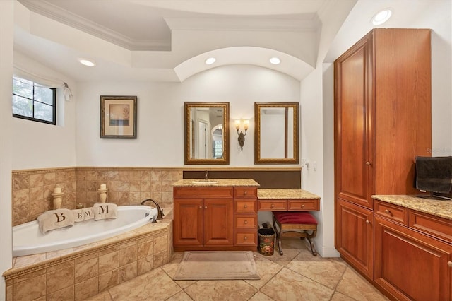 bathroom with vanity, ornamental molding, and tiled bath