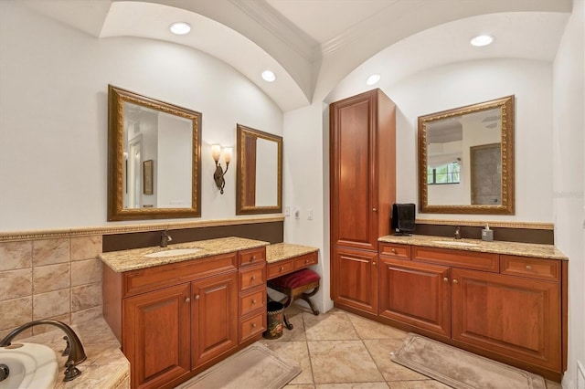 bathroom featuring crown molding, a tub to relax in, vanity, and tile walls