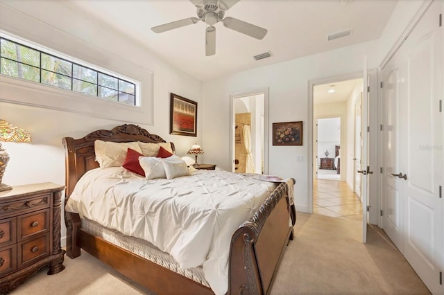 bedroom with connected bathroom, light colored carpet, and ceiling fan