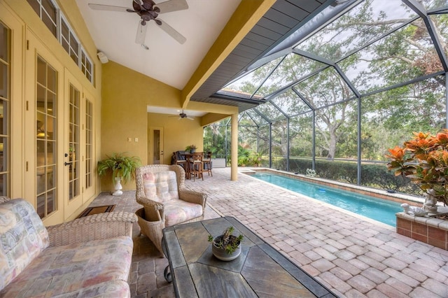 view of pool with a lanai, a patio area, ceiling fan, and french doors