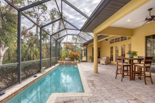 view of pool with a lanai, pool water feature, a patio, and ceiling fan