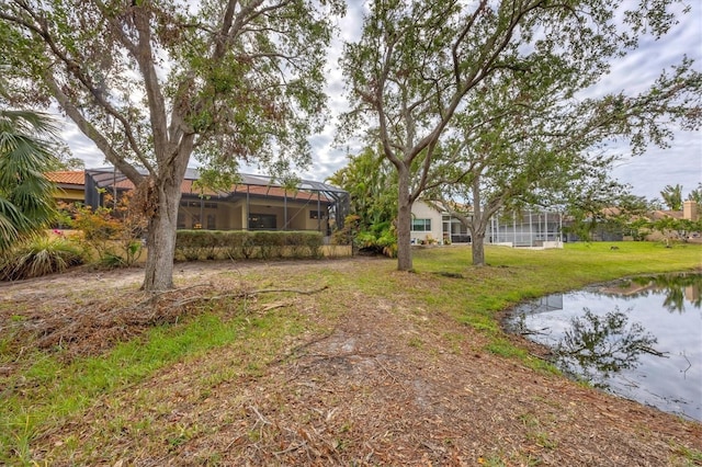 view of yard with a water view and a lanai