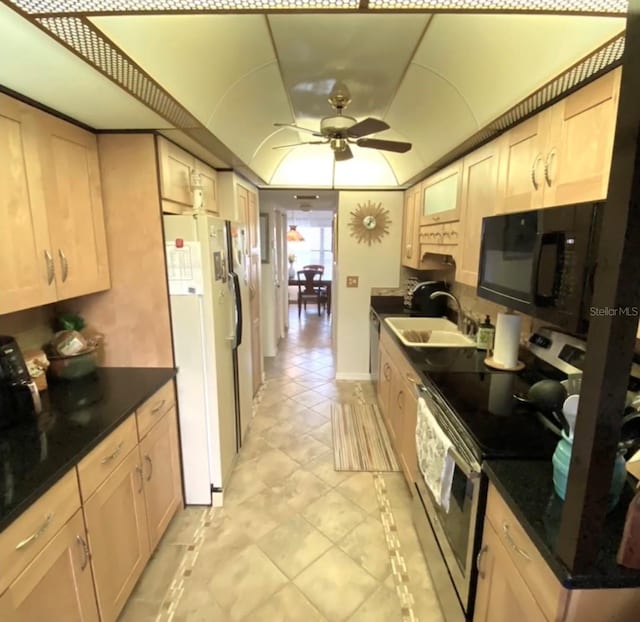 kitchen with stainless steel electric stove, light brown cabinetry, sink, white fridge, and ceiling fan