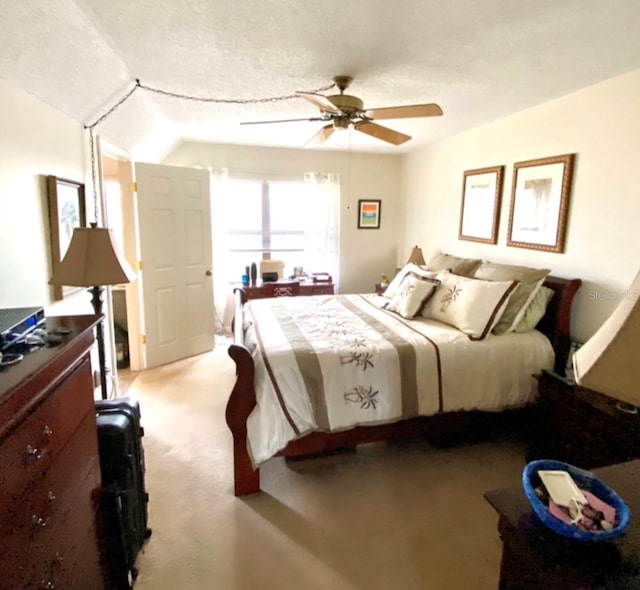 carpeted bedroom with vaulted ceiling, a textured ceiling, and ceiling fan