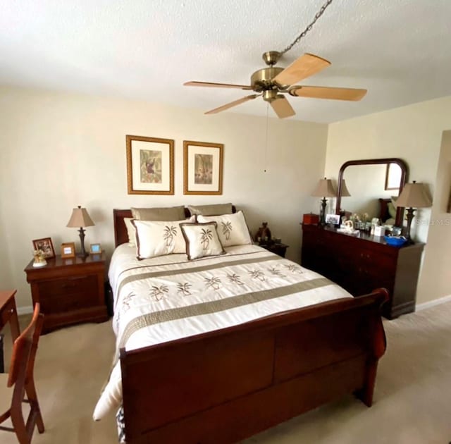 carpeted bedroom with ceiling fan and a textured ceiling