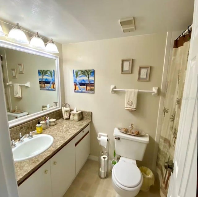 bathroom with vanity, walk in shower, tile patterned floors, and toilet