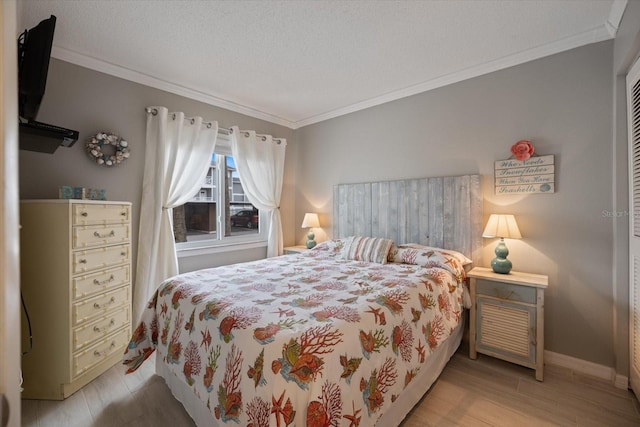 bedroom with ornamental molding, light hardwood / wood-style floors, and a textured ceiling