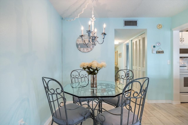 dining space with an inviting chandelier and light hardwood / wood-style floors