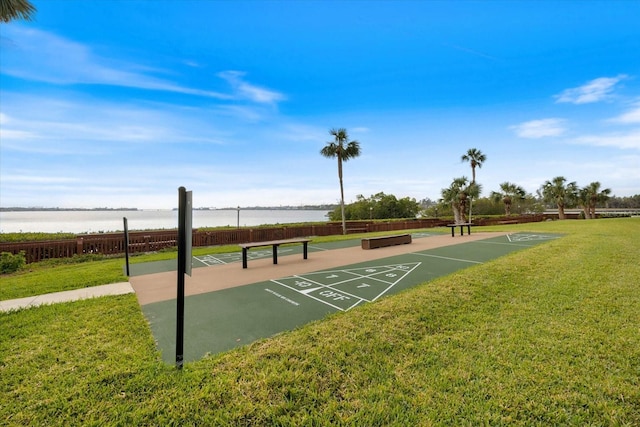 view of home's community with a water view and a lawn